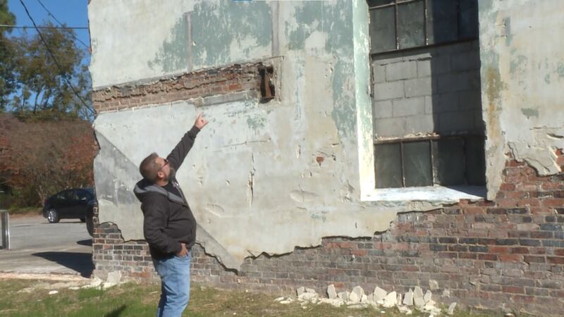 Scalpi examines the damage of the shared wall.