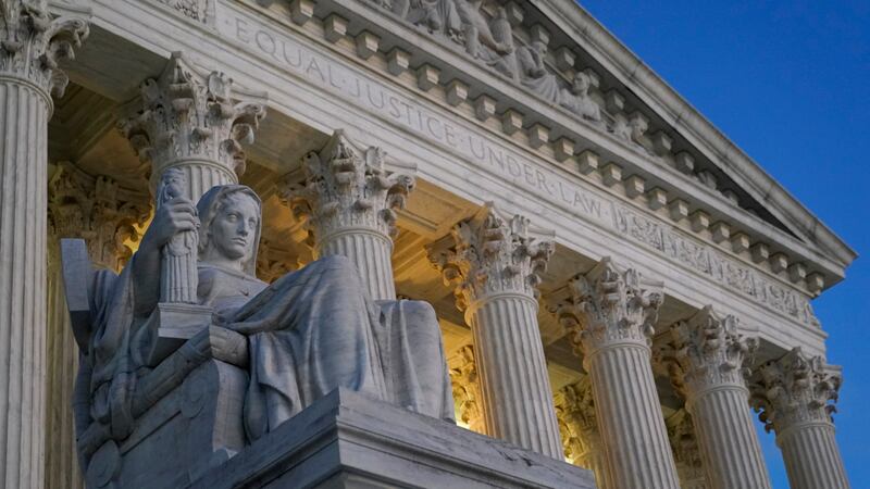 FILE - Light illuminates part of the Supreme Court building on Capitol Hill in Washington,...
