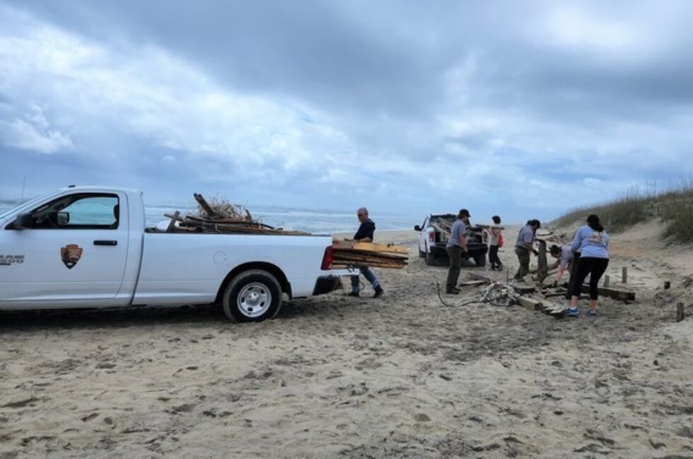 Volunteers and National Park Service staff work together to place collected debris into vehicle.