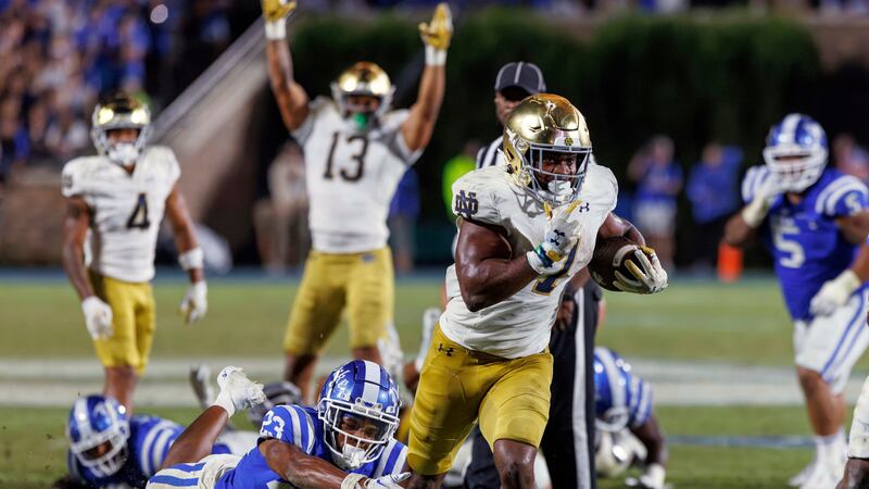 Notre Dame's Audric Estimé (7) carries the ball past Duke's Terry Moore (23) for the go-ahead...